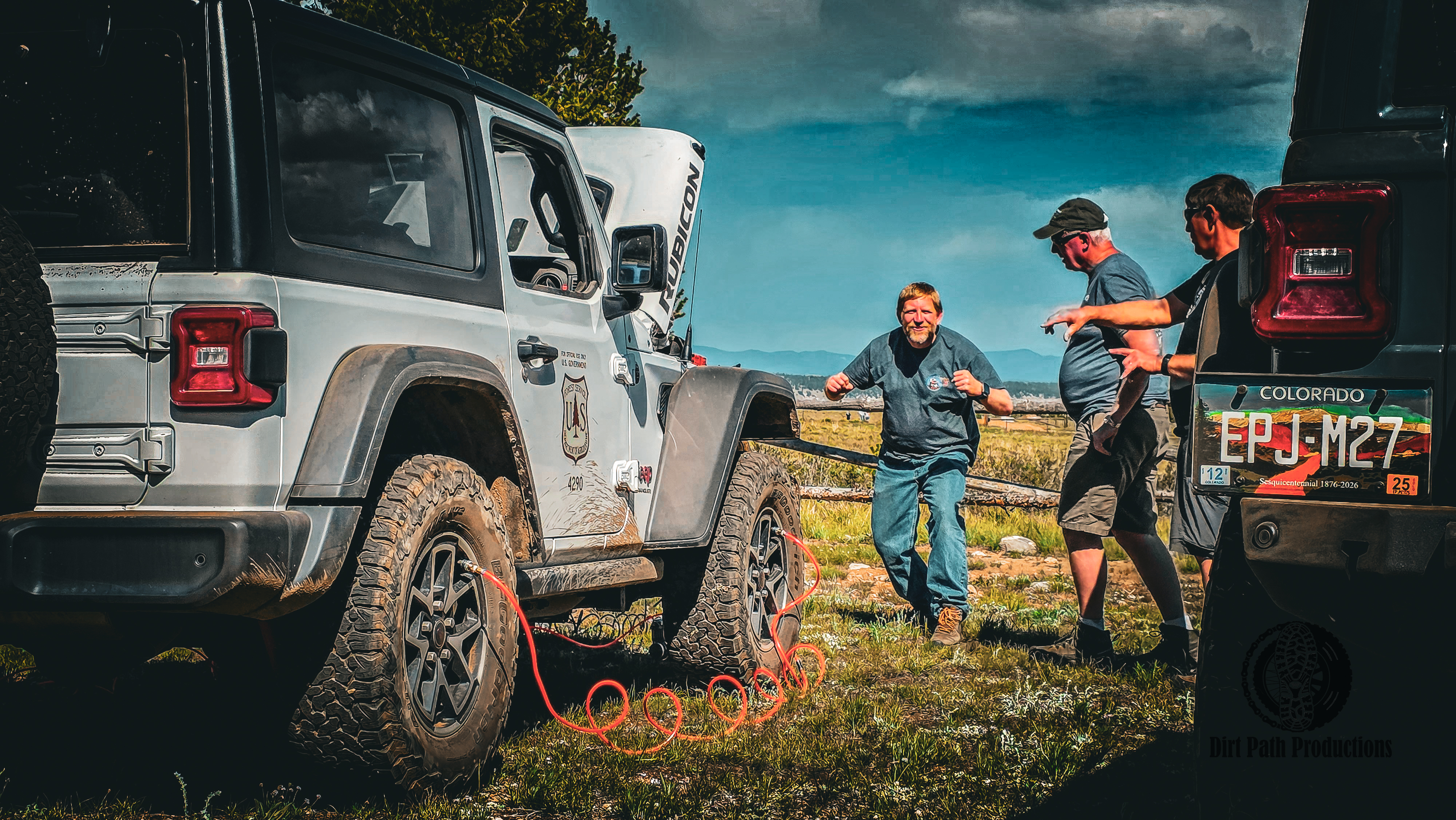 Group of off-roaders chatting next to Jeeps and a Forest Service vehicle