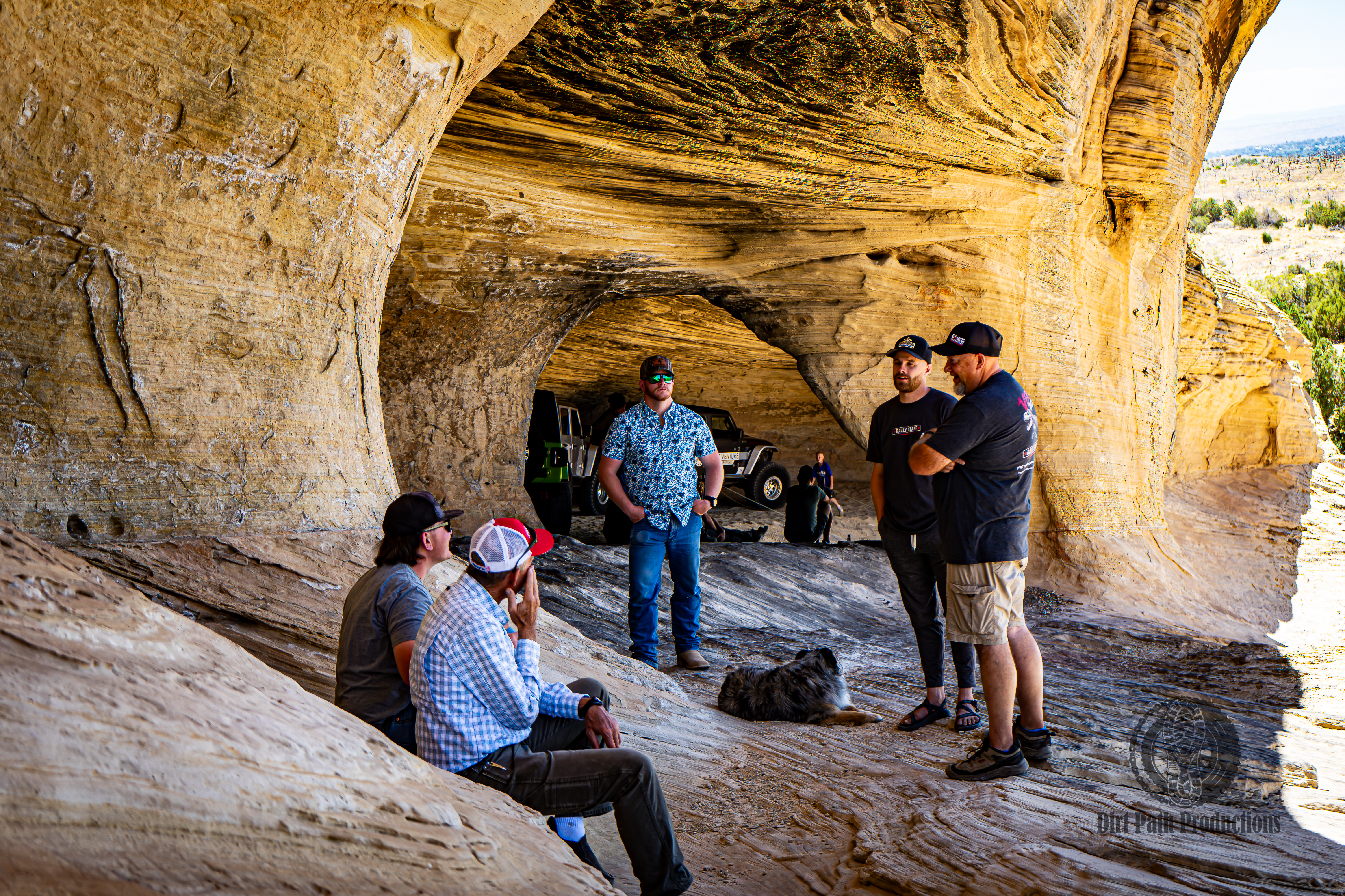 Off-roaders hanging out under a sandstone overhang